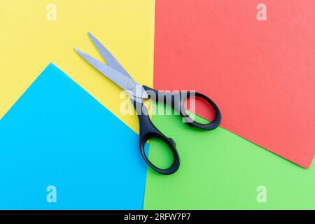 Scissors placed on colored papers, after some edits. Stock Photo