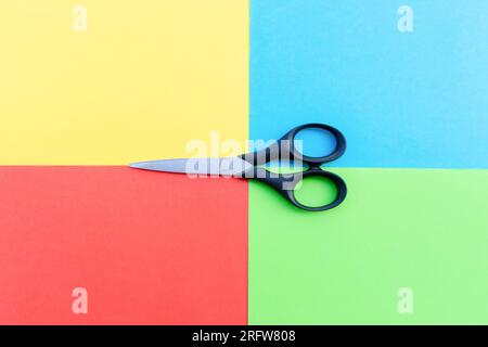 Scissors placed on colored papers, after some edits. Stock Photo
