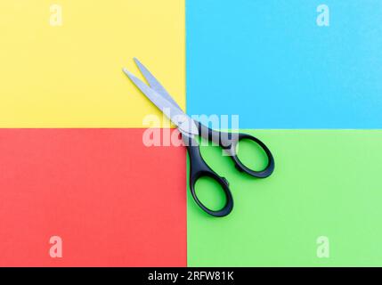 Scissors placed on colored papers, after some edits. Stock Photo