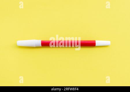 Red marker isolated on yellow background, after some edits. Stock Photo