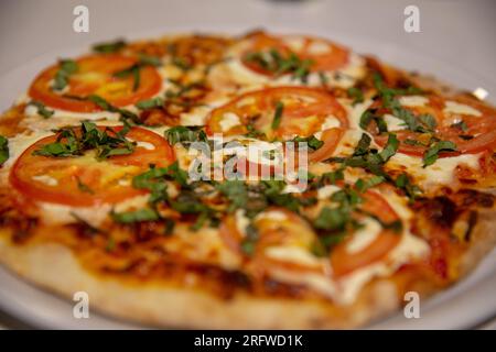 Margherita Pizza freshly baked topped with basil and extra cheese Stock Photo