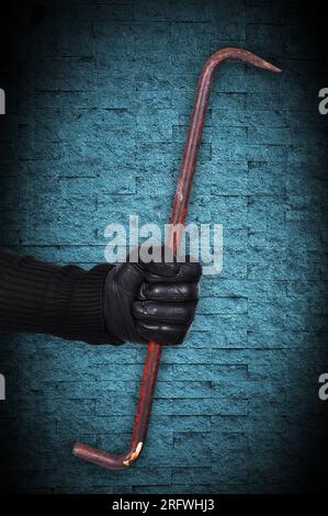 hand holding nail puller on blue background Stock Photo