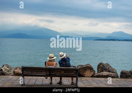 couple sitting on a bench in the lake garda Stock Photo