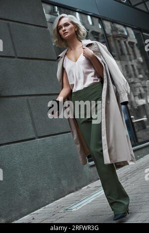 Fashion. Young stylish woman walking on the city street looking forward thoughtful full body shot Stock Photo