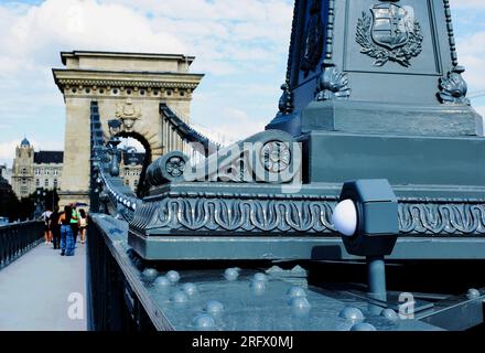 perspective view of the renovated Chain Bridge. tour boat on the Danube. The Buda Castle in background. reopening it to the public, people walking. Stock Photo