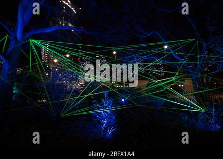 Trees with green neon tape - Canary Wharf Winter Lights art festival  2018 Stock Photo