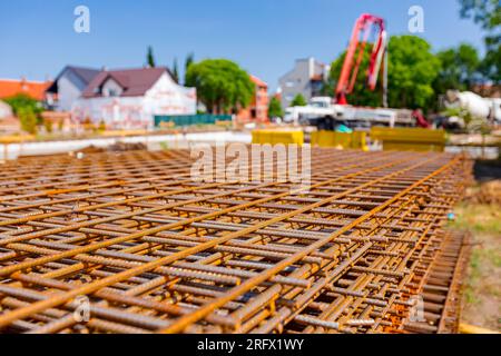 Pile of rusty rectangle steel reinforcement for concrete ready for installation placed at construction site. Stock Photo