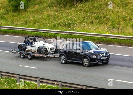 2015 Gkd Legend light-weight performance sports car Petrol 2793cc on Brian James trailer being towed by 2016 Nissan Juke Tekna DCI; travelling on the M6 motorway in Greater Manchester, UK Stock Photo