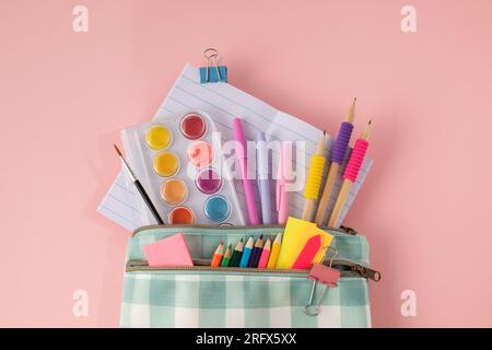 Stylish stationery for school and office in a pencil case on a pink background.  Stock Photo