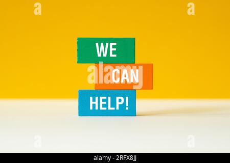 We can help - word concept on building blocks, text, letters Stock Photo