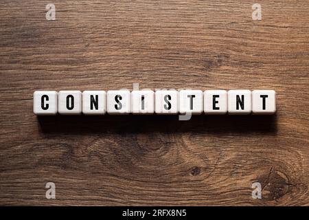 Consistent - word concept on building blocks, text, letters Stock Photo