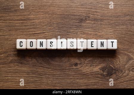 Consistent - word concept on building blocks, text, letters Stock Photo