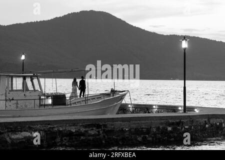 Ein Brautpaar das einen Spaziergang macht und dabei den Sonnenuntergang in Griechenland genießt. Stock Photo