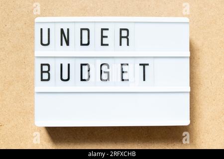 Lightbox with word under budget on wood background Stock Photo