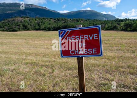 Sign written in French indicating a hunting reserve, an area in which it is forbidden to hunt in order to allow the renewal of game Stock Photo