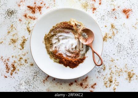 A plate with mixed up spices and an abstract mess of spices all around. Stock Photo