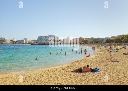 People enjoying a warm September day on the beach in Magaluf, with hotels in the background Stock Photo