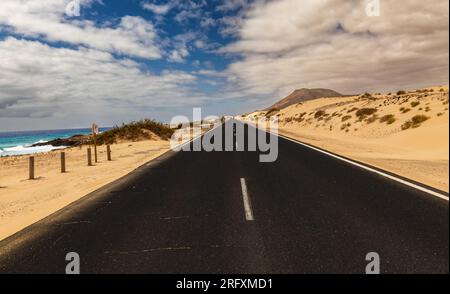 road in the middle of dunes on the seashore of fuerteventura Stock Photo