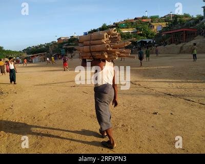 Rohingya refugee man is carrying fire wood Stock Photo