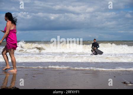 Kent UK. 06th August 2023. UK Weather. Strong  winds can be felt and choppy sea water seen at Kent south coast while Storm Antoni hits England' south west coast with near-80mph gusts. People still enjoying sunny day on beach swimming in incoming waves. Credit: xiu bao/Alamy Live News Stock Photo