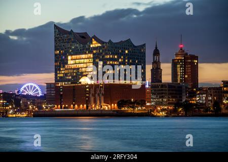 Hamburg: Elbphilharmonie, Michel and Ferry Wheel of the Hamburger Dom in the evening, seen from the Schuppen 52 southern of the Elbe river Stock Photo