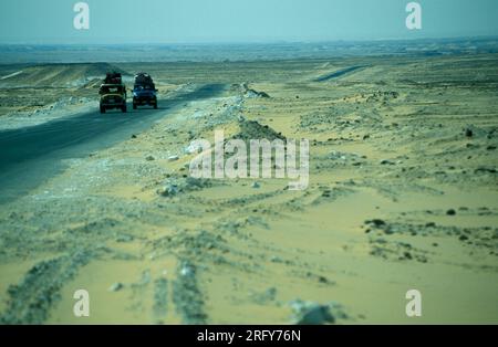 a Tourist Tour with Cars in the Landscape and Nature in the White Desert near the Village of Farafra in the Libyan or western desert of Egypt in North Stock Photo