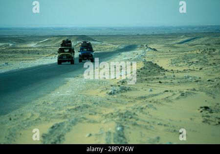 a Tourist Tour with Cars in the Landscape and Nature in the White Desert near the Village of Farafra in the Libyan or western desert of Egypt in North Stock Photo