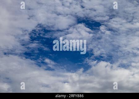 Blue clearing between white clouds Stock Photo