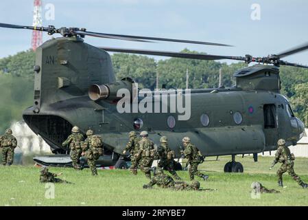 British Army troops heading to board a Royal Air Force Boeing Chinook HC2 helicopter ZA705. Battlefield extraction war scenario at RAF Fairford show Stock Photo