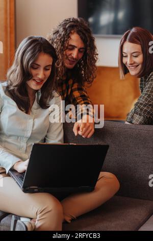 Young, intelligent software developers working as team at the office sitting on a grey sofa Stock Photo