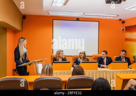 Group of students and professors getting ready to hear their student present a project Stock Photo