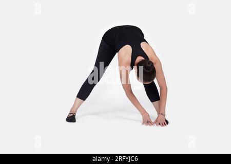 Specialized trauma releasing exercises for elderly people, 55 years old woman trainer posing for exercises. Hamstring pose, in the studio isolated on Stock Photo