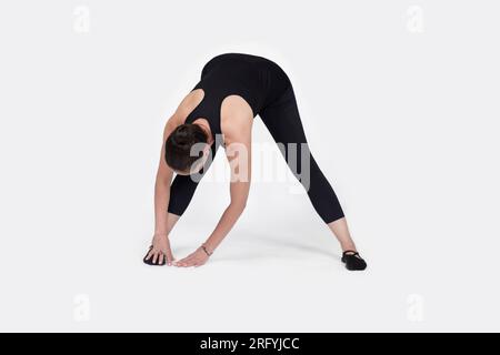 Specialized trauma releasing exercises for elderly people, 55 years old woman trainer posing for exercises. Hamstring pose, in the studio isolated on Stock Photo