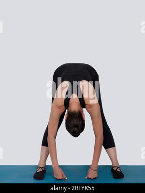 Specialized trauma releasing exercises for elderly people, 55 years old woman trainer posing for exercises. Hamstring pose, in the studio isolated on Stock Photo