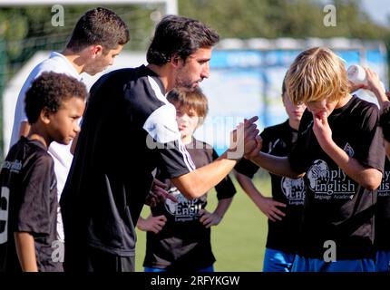 Trainer gave direction to young kids children teenage boys - playing football soccer game sports in Alcanena Municipality, Portugal. Municipal Stadium Stock Photo