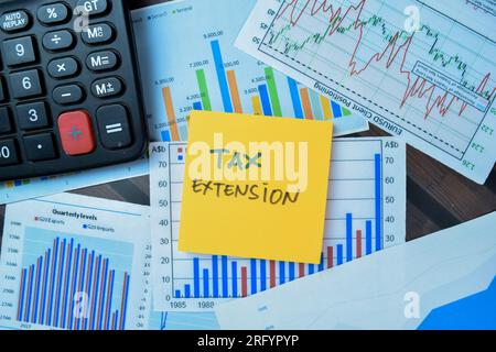 Concept of Tax Extension write on sticky notes isolated on Wooden Table. Stock Photo