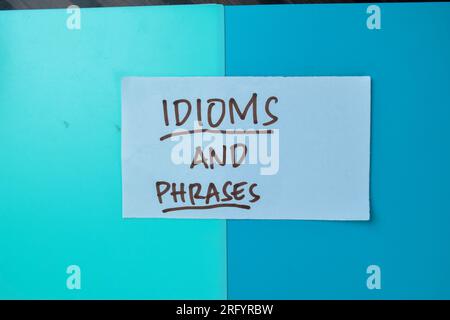 Concept of Idioms and Phrases write on sticky notes isolated on Wooden Table. Stock Photo