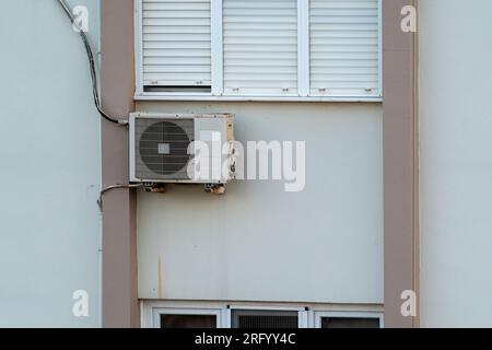 Split air conditioner outdoor unit hung outside the building. Stock Photo