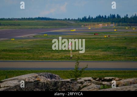 Helsinki / Finland - AUGUST 5, 2023: An airport tarmac with a windsock. Runway markings and lights. Stock Photo