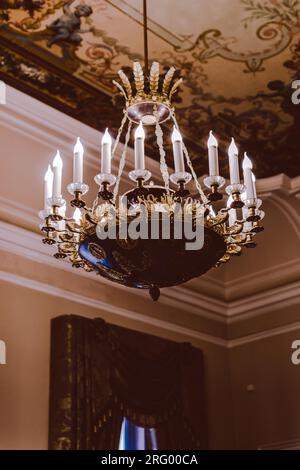 Royal crystal historical chandelier with candles. Baroque architecture and details. Dark beauty aesthetics. Vertical shot Stock Photo