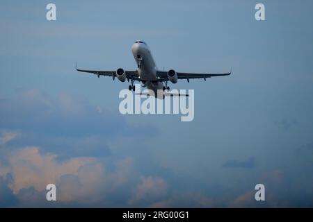 Helsinki / Finland - AUGUST 5, 2023: An airplane taking off from the runway against a bright cloudy sky. Stock Photo