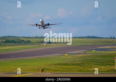 Helsinki / Finland - AUGUST 5, 2023: An airplane taking off from the runway against a bright blue sky. Stock Photo
