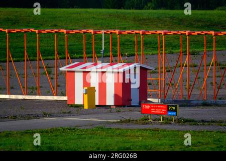 Helsinki / Finland - AUGUST 5, 2023: A striped airfield building with a sign prohibiting unauthorized persons Stock Photo
