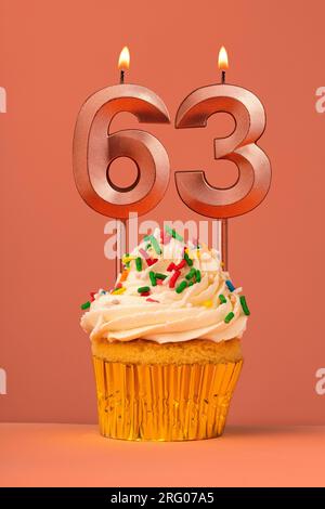 Birthday cake with candle number 63 - Coral fusion background Stock Photo