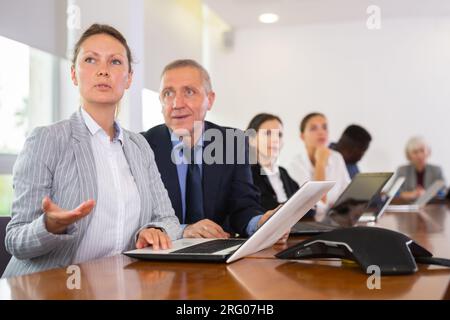 Two age-diverse male and female professionals discussing project strategy at office Stock Photo