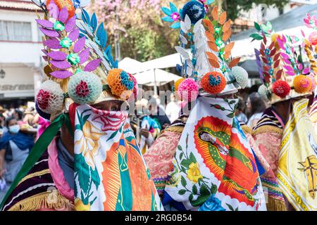 Mexican artisans dressed in their traditional regional costumes parade down the street marking the start of the Palm Sunday Handcraft Market or Tianguis de Domingo de Ramos April 9, 2022 in Uruapan, Michoacan, Mexico. The week long handicraft market is considered the largest in the Americas. Stock Photo