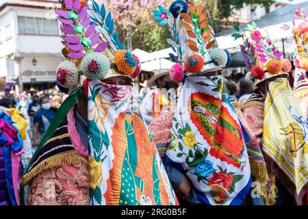 Mexican artisans dressed in their traditional regional costumes parade down the street marking the start of the Palm Sunday Handcraft Market or Tianguis de Domingo de Ramos April 9, 2022 in Uruapan, Michoacan, Mexico. The week long handicraft market is considered the largest in the Americas. Stock Photo