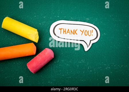 THANK YOU. Speech bubble with text on a green chalkboard. Stock Photo