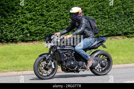 Whittlebury,Northants.,UK - Aug 6th 2023. 2010 Triumph Speed Triple 1050 motorcycle travelling through an English village. Stock Photo