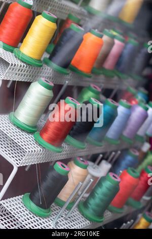 Colorful spools of thread on a rack Stock Photo